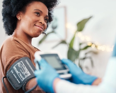 a medical provider checks the blood pressure of a young woman